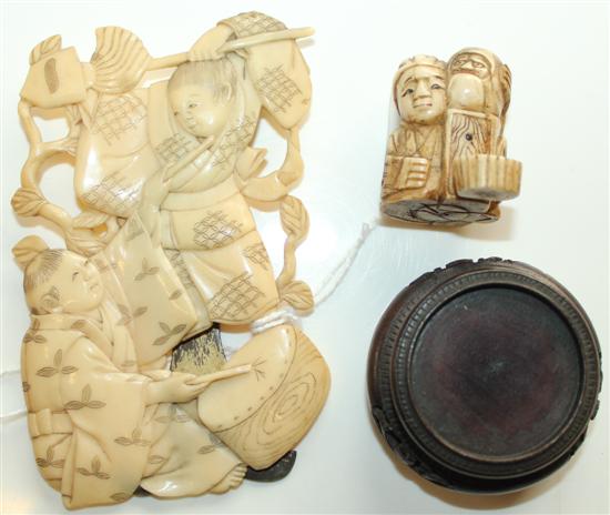 Japanese carved ivory okimono, seated man with puppet & relief-carved ivory panel with figures, on easel stand